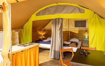 Intérieur d’une tente lodge, glamping dans l’Aude au camping Rives des Corbières à Port-Leucate