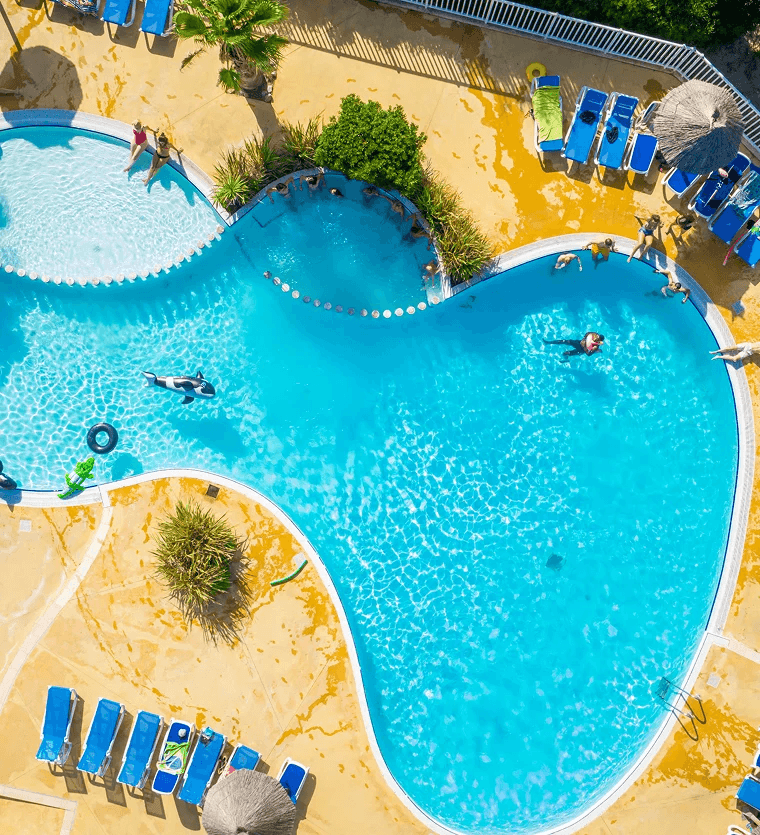 Vue aérienne de la piscine avec transats de l’espace aquatique de Rives des Corbières, camping avec piscine dans l’Aude