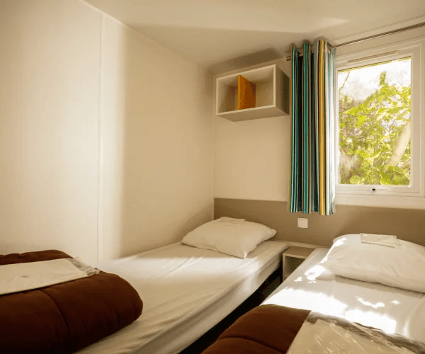 Mobil-home Alizée en location au camping Rives des Corbières à Port-Leucate dans l’Aude en région Occitanie : chambre avec 2 lits une place