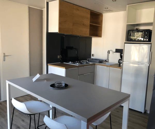 Cuisine et coin repas du mobil-home Bora en location au camping Rives des Corbières à Port-Leucate dans l’Aude