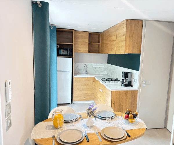 Coin repas et cuisine du mobil-home Zéphyr en location au camping Rives des Corbières à Port-Leucate dans l’Aude