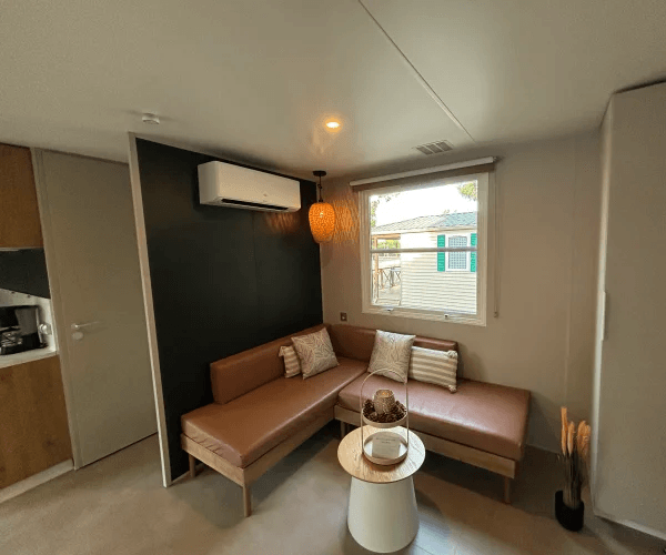 Coin salon avec canapé-lit du mobil-home Zéphyr en location au camping Rives des Corbières à Port-Leucate dans l’Aude