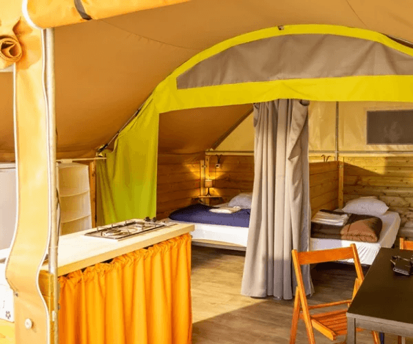 Intérieur de la Tente Lodge avec chambre et coin cuisine